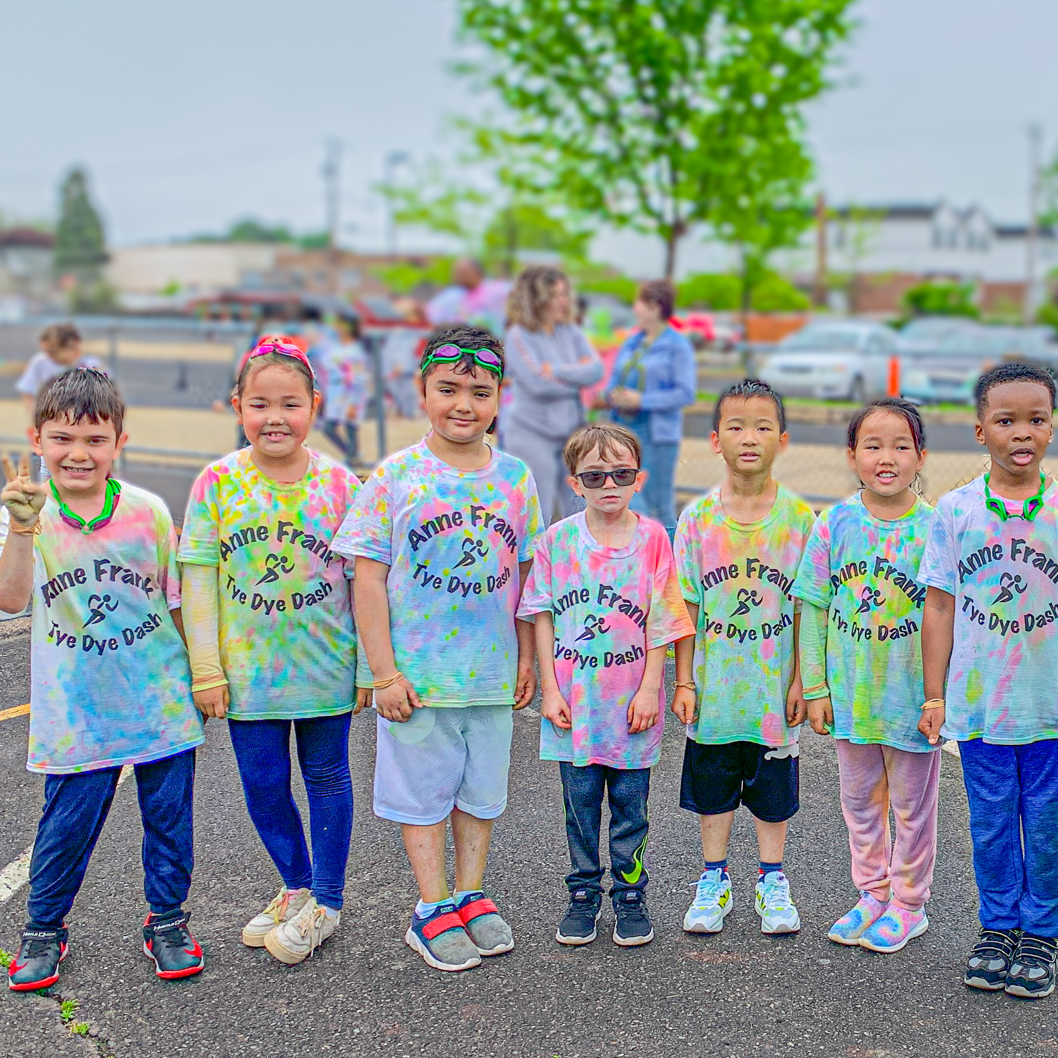 Group of students in tie dye shirts after participating in the 2025 Anne Frank Elementary fun run