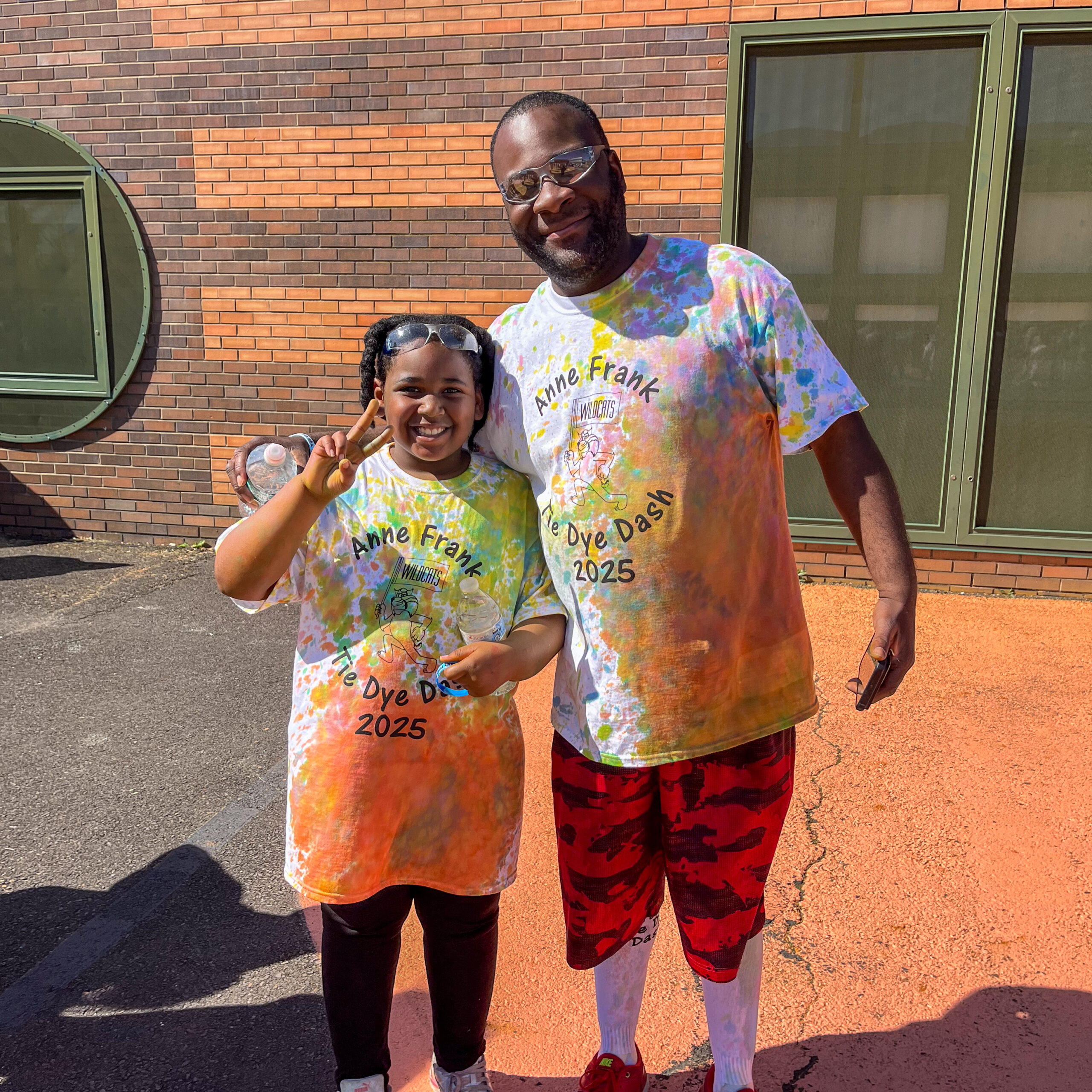 Student and dad smiling in colorful shirts at the 2025 Tie Dye Dash event