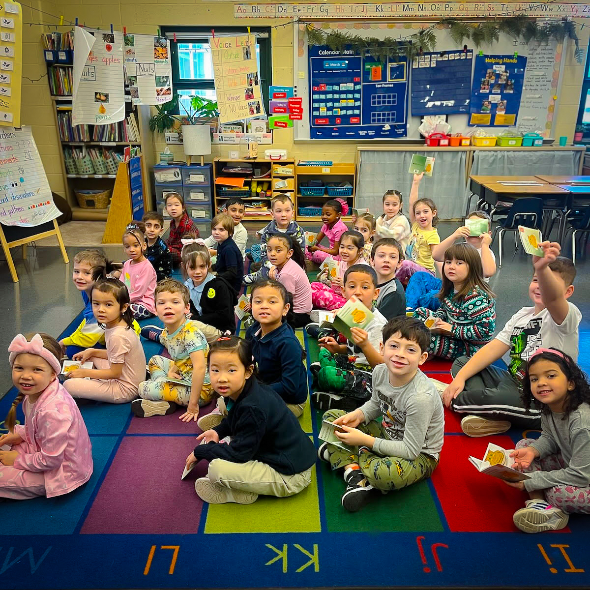 indergarten students sitting on a colorful carpet during classroom activity