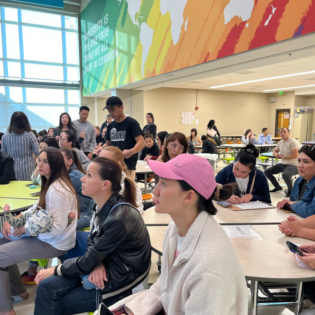 Families participating in an informative workshop in the school cafeteria